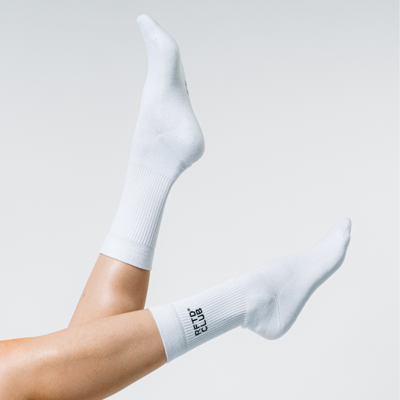 Die unteren Beine einer Frau werden in die Kamera gehalten. Zu sehen sind die Socken die sie trägt.