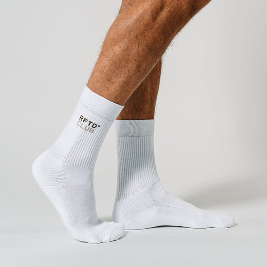 Zu sehen sind die unteren Beine eines Mannes, der steht und der die Socken von RFTD trägt.